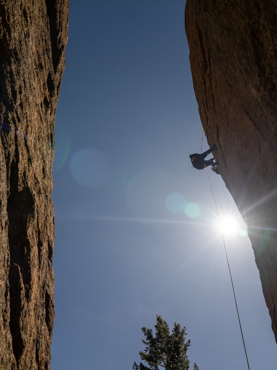 A climber rappelling between rock walls